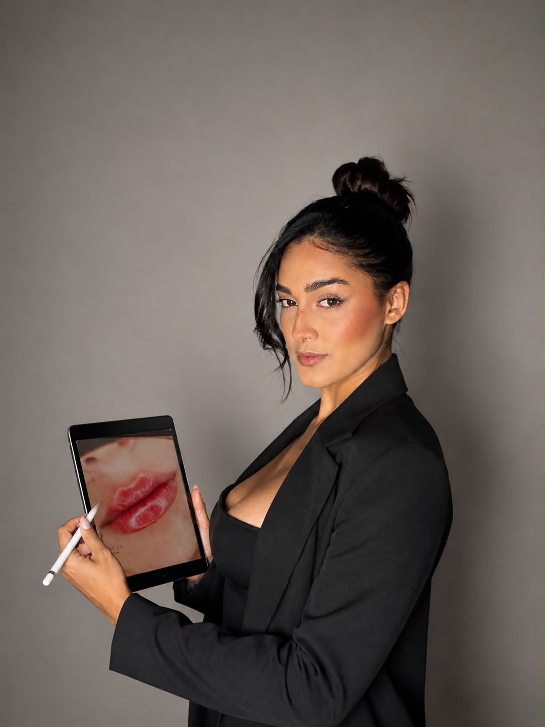 Bruna Maioli segurando um tablet com desenho de preenchimento labial